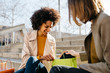 © Westend61 - Two happy women with shopping bags sitting on stairs checking the purchase