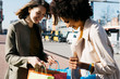 © Westend61 - Two happy women with shopping bags in the city checking the purchase
