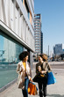© Westend61 - Two happy women with shopping bags and takeaway coffee walking in the city