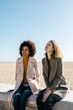 © Westend61 - Two friends sitting on the promenade enjoying leisure time