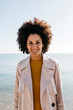 © Westend61 - Portrait of smiling woman with the sea in background