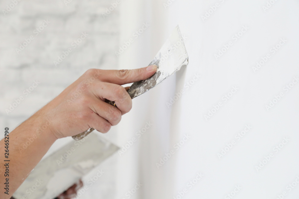 Plastering wall with putty-knife, close up image. Fixing wall surface and preparation for painting. - obrazy, fototapety, plakaty 