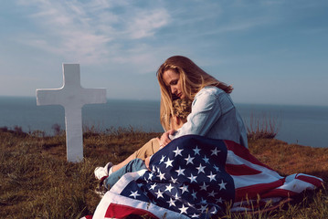 mother with son in the cemetery near the grave of the father of the American soldier who died in the ridge point defending the sovereignty and independence of the United States of America