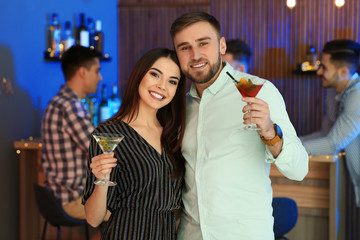 Wall Mural - Young couple with martini cocktails at party