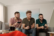 © New Africa - Emotional friends playing video games at home