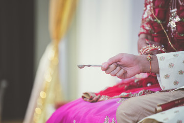 Indian hindu wedding ceremony ritual items, spoon and hands close up