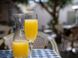 Orange juice mimosa drink in glass and carafe for brunch outdoors 