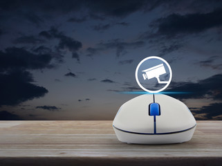 cctv camera flat icon with wireless computer mouse on wooden table over sunset sky, Business security and safety online concept