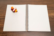 Red and yellow wooden airplane toy on white blank notebook on wooden table