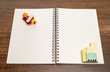 Red wooden airplane on blank white notebook with ceramic building toy