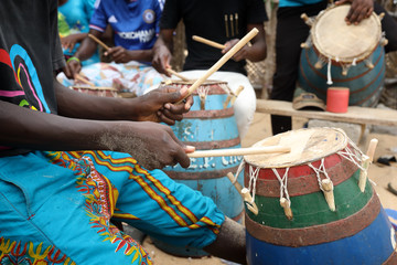 Close-up of a musician playing traditional drums on the beach in Accra, Ghana