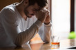 © fizkes - Man sitting on bar counter feels depressed drinking alcohol drink