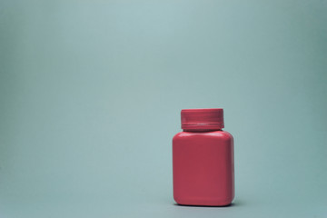 Poster - Pink bottle for pills on a gray background.