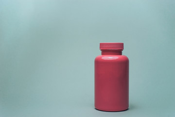 Poster - Pink bottle for pills on a gray background.