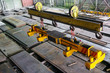 Overhead traveling crane with magnetic grippers traverse for lifting steel sheets. Industrial indoors area.