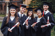 © Тарас Нагирняк - Happy graduates. Five college graduates standing in a row and smiling. Nice time!