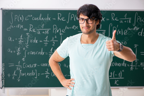 Fotomural Young male student mathematician in front of chalkboard