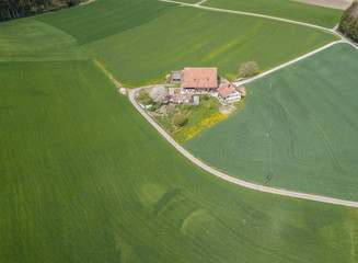 Wall Mural - Aerial view of farm house in remote area in rural landscape in Switzerland.