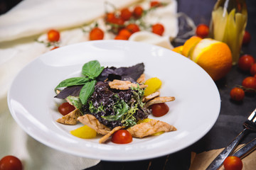 Wall Mural - salad with grilled chicken fillet, basil, cherry tomatoes and orange in a white plate.