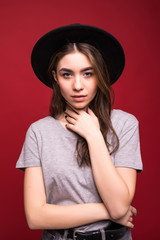 Wall Mural - Portrait stylish girl wearing black hat isolated over red background