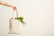 © Pixel-Shot - Female hand with eco bag on white background. Zero waste concept