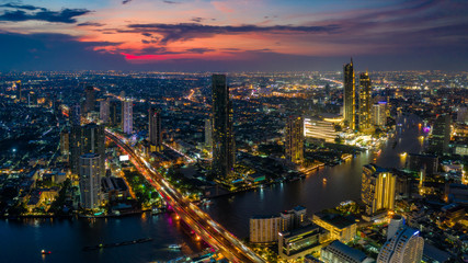 Fototapete - Aerial view of Bangkok skyline and skyscraper with BTS skytrain Bangkok downtown. Panorama of Sathorn and Silom business district Bangkok Thailand at sunset.