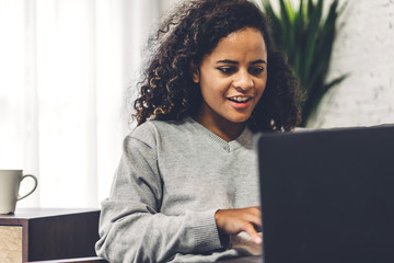 Wall Mural - Young african american black woman relaxing and using laptop computer.woman checking social apps and working.Communication and technology concept