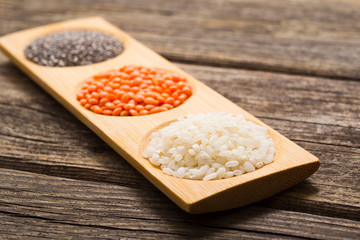 Wall Mural - white rice, red lentil, chia seeds, old wooden table