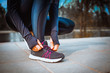 © Vasily Makarov - girl in running marathon stopped to lacing her shoelaces on her sneakers - sport training workout health concept