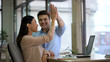 © motortion - Happy freelancers giving high five and smiling, company achievement, success