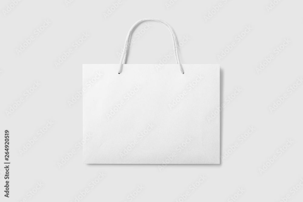 Mockup of a blank white paper shopping bag with handles on light grey ...