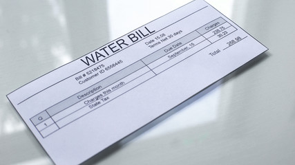 water bill lying on table, payment for services, month expenses, tariff close up