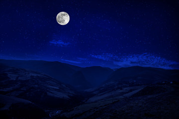 Wall Mural - mountain road through the forest on a full moon night. scenic night landscape of country road at nig