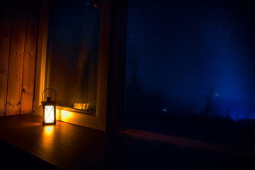 Night scene of stars seen through the window from dark room. Night sky inside dark room. Long exposure shot