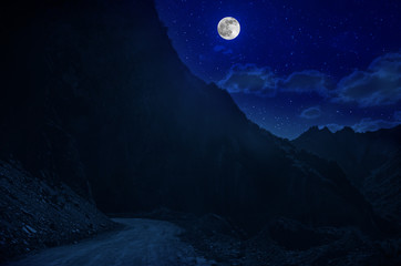 Wall Mural - mountain road through the forest on a full moon night. scenic night landscape of country road at nig