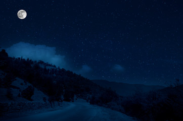 Wall Mural - mountain road through the forest on a full moon night. scenic night landscape of country road at nig