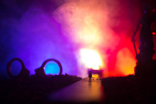 Legal Law Concept. Silhouette Of Handcuffs With The Statue Of Justice On Backside With The Flashing Red And Blue Police Lights At Foggy Background. Selective Focus