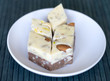 © Evgenia - Oriental dessert halva with pistachio, almond, cashew nuts, peanut, walnut  on a  plate. Image. sweets from Iran Turkish Delight. Isolated on background