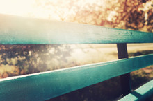 Wooden Blue Bench In City Park. With Sun Rays And Bokeh. Selective Focus