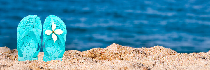 Wall Mural - Woman flip flops stuck in the sand on a beach, panoramic summer background with copy space