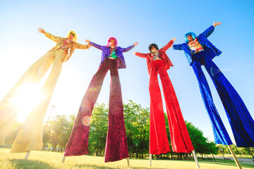 Wall Mural - Young people on stilts posing against the blue sky.