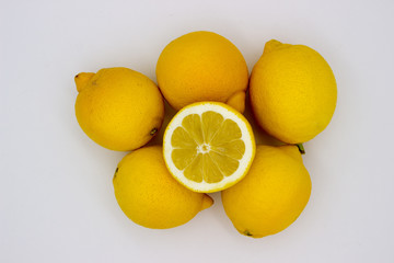 Wall Mural - Many lemons and a half of a lemon isolated image on a white background