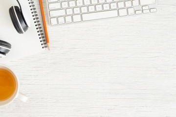 Wall Mural - flat lay photo of office desk with earphone and keyboard,copy space on white background with noteboo