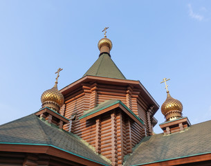 Wall Mural - New wooden Orthodox church, dome with a cross and blue sky. Russia.