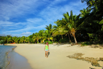 Wall Mural - Young woman walking on a beach on Drawaqa Island, Yasawa Islands, Fiji