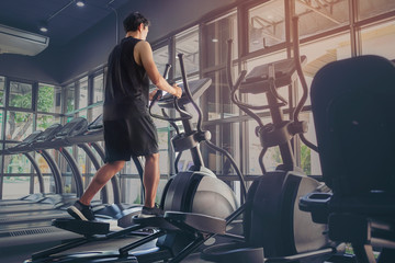 Young people running in machine treadmill at fitness gym club..Young sporty man and woman training in modern gym