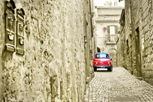 View Of A Small Car In The Historic Cityscape In Orvieto, Italy With Vintage And Isolated Color Effect. 