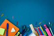 © Anna - School supplies on blue background. Top view. Copy space.