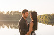 © satura_ - People, love and nature concept - Young beautiful woman and handsome man embracing each other over water background