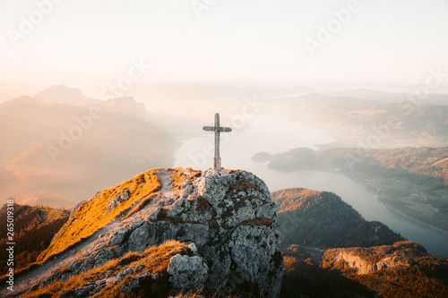 Cuadros en Lienzo Mountain summit cross on alpine peak at sunset
